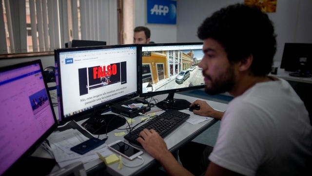 Fake-News im Visier: Ein Mitarbeiter der Nachrichtenagentur AFP prüft Nachrichten auf ihre Echtheit. (Archivbild) Bild: Mauro Pimentel/AFP